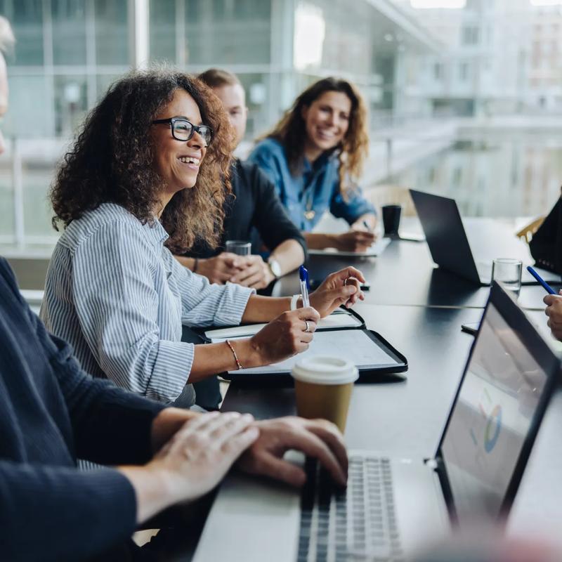 Multi-ethnic business people smiling during a meeting in conference room. Team of professionals having meeting in boardroom.